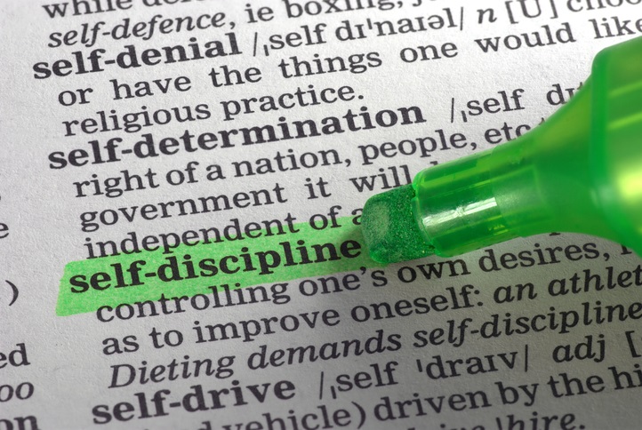 A dictionary page with the definition for "self-discipline" and the words "self-discipline" being highlighted with a green highlighter marker