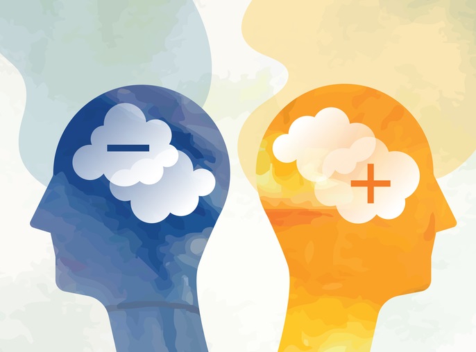 Picture of 2 human head silhouettes, one blue with a negative sign and one yellow with a positive sign, to depict negative vs positive thinking