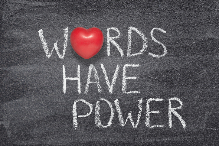 "Words have power" written on a chalkboard. The "O" in "words" is a red heart